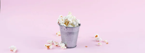 Popcorn i en hink på rosa bakgrund — Stockfoto