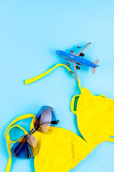 파란색 배경에 탑 뷰 장난감 비행기, 수영복과 안경 — 스톡 사진