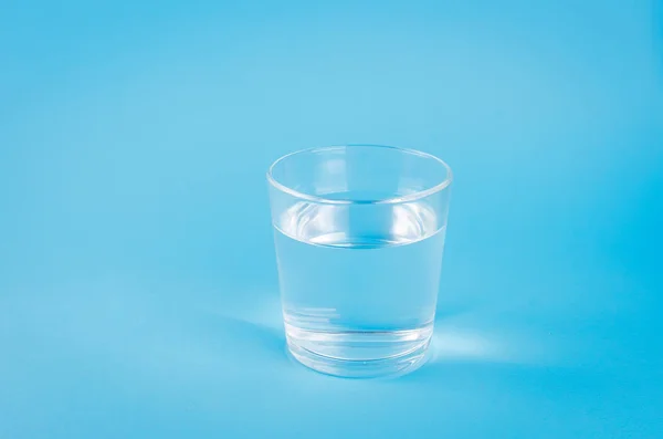 Mavi arka planda bir bardak su