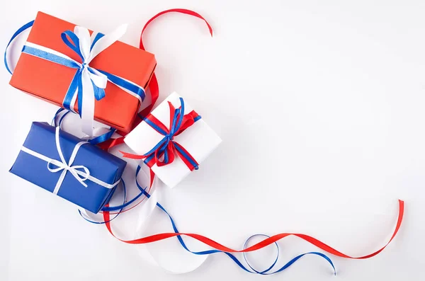 Caixas de presente vermelho, azul e branco com fitas em um backgroun branco — Fotografia de Stock