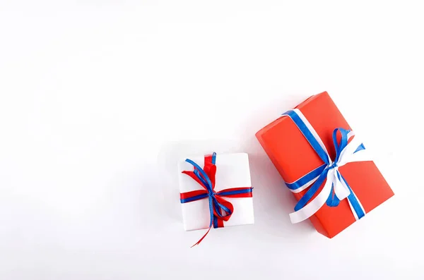 Красный, синий и белый подарочные коробки с лентами на белой спинке — стоковое фото