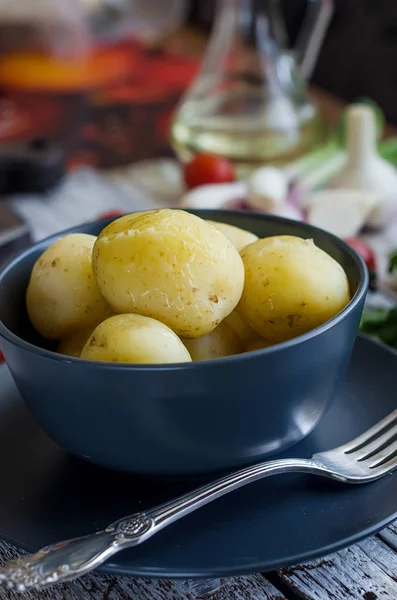 Tasty boiled potatoes in black bowl — Stock Photo, Image