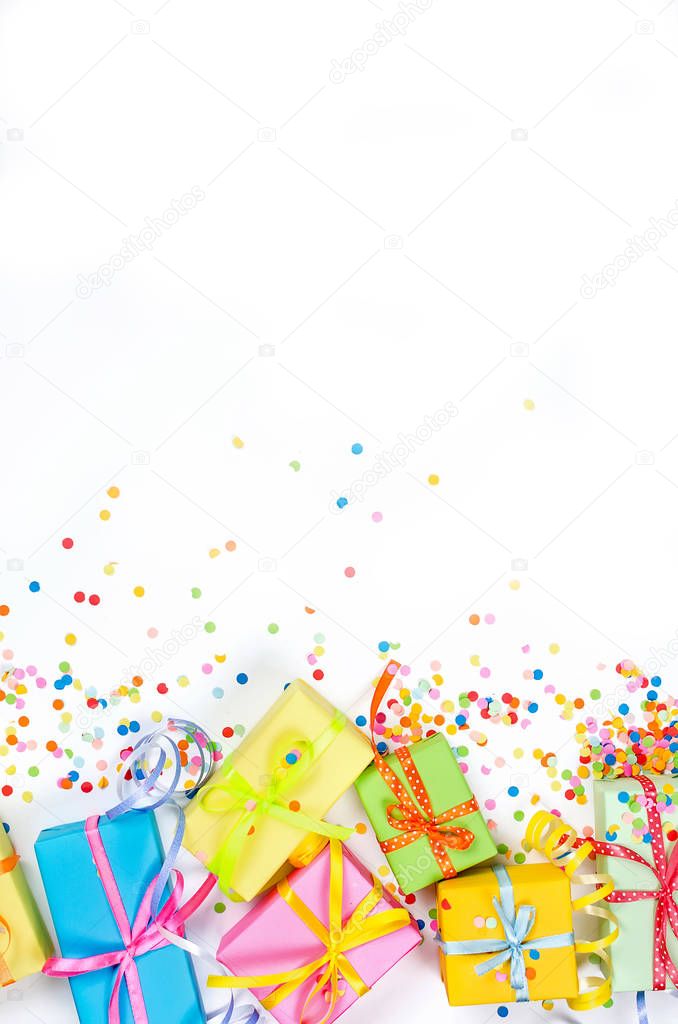 Colorful assorted confetti with serpentine and gift boxes on whi