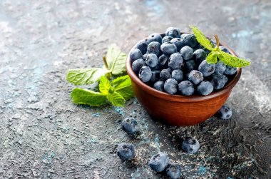 koyu beton arka plan üzerinde kase olgun yaban mersini