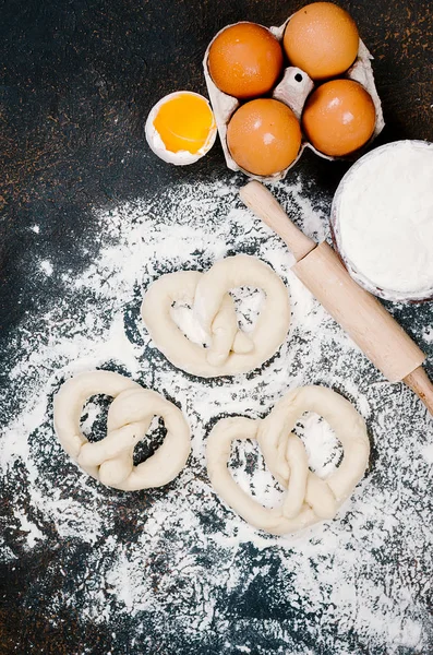 Raw pretzel on a floor ready to be baked and ingredients — Stock Photo, Image