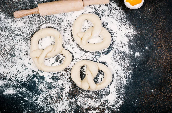 Raw pretzel on a floor ready to be baked and ingredients — Stock Photo, Image