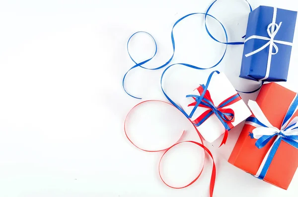 Caixas de presente vermelho, azul e branco com fitas em um backgroun branco — Fotografia de Stock