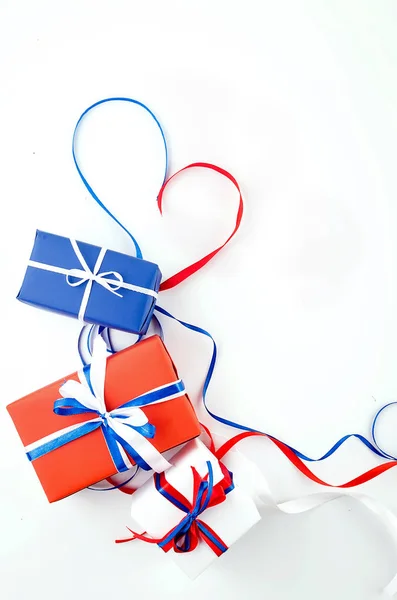 흰색 백그룬에 리본이 달린 빨간색, 파란색 및 흰색 선물 상자 — 스톡 사진