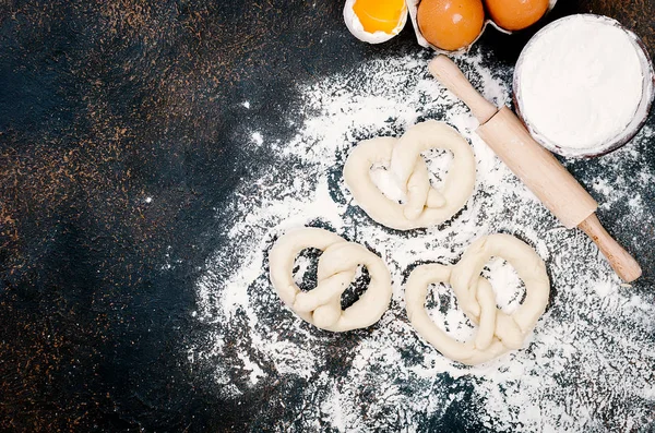 Raw pretzel on a floor ready to be baked and ingredients — Stock Photo, Image