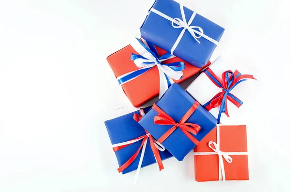 Rode, blauwe en witte geschenkdozen met linten op een witte backgroun — Stockfoto