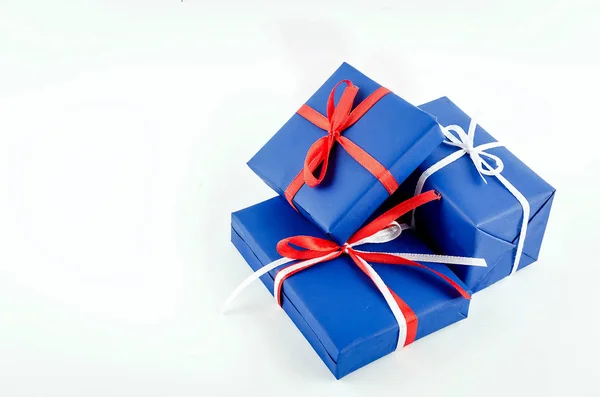 Rode, blauwe en witte geschenkdozen met linten op een witte backgroun Stockafbeelding