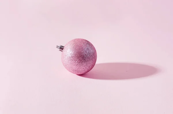 Roze kerstballen op roze papieren achtergrond — Stockfoto