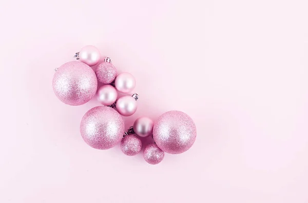 Roze kerstballen op roze papieren achtergrond — Stockfoto