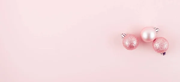 Roze kerstballen op roze papieren achtergrond — Stockfoto