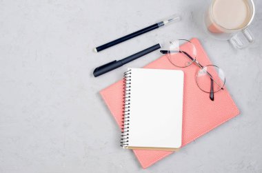 İçinde not defterleri, boş kağıtlar, malzemeler, bardaklar ve bir fincan kahve olan gri çalışma masası. Metnin için en üstte boşluk var. Düz yatıyordu. Asgari tarz ev ofisi ya da Modern Serbest İşyeri.