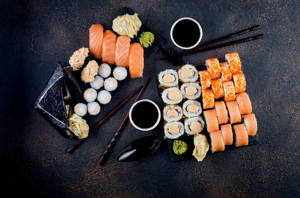 Smakrika Sushirullar Stenplatta Med Såser Ätpinnar Ingefära Och Wasabi Mörkt — Stockfoto