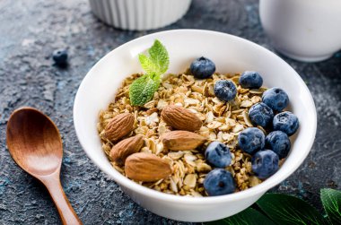 Kahvaltıda yaban mersinli tahıl gevreği ve bir fincan çay, fındıklı ev yapımı müsli ve az tatlı olsun diye bal..