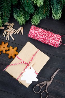 Noel kompozisyonu. İçinde bir sürü el işi hediye kutusu, köknar brandı ve siyah ahşap masa üzerinde zencefilli ekmek var. Tatil konsepti arkaplan, üst görünüm, kopyalama aralığı