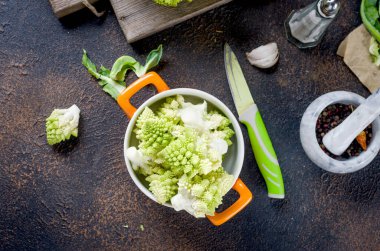 Taze yeşil Romanesco, Çiğ Organik Lahana Koyu ahşap arka planda bir kesim tahtasının üzerinde tabakta pişirmeye hazır