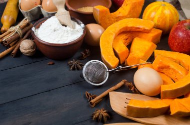 Sonbahar pişirme konsepti. Balkabağı, elma, fındık, sinamon, yumurta ve unla çerçevelenmiş ahşap masa. Malzemelerle pişirme işlemi. Üst Manzara. Boşluğu kopyala,