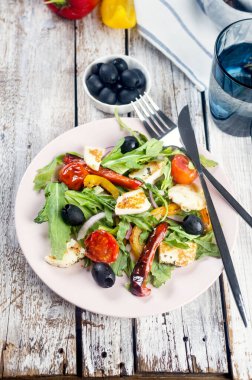 Izgara halloumi peynirli salata, roka yaprağı, marul, zeytin, ızgara domates ve biber.