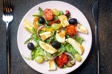 Izgara halloumi peynirli salata, roka yaprağı, marul, zeytin, ızgara domates ve biber.