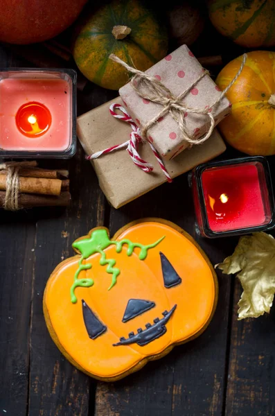 Herbstkomposition mit Lebkuchen zu Halloween, Kerzen, Kürbissen und Blättern auf dem Holztisch. — Stockfoto