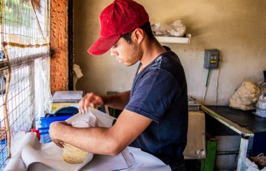 Genç adam tipik bir Meksika dükkanında nixtamal tortilla satıyor.