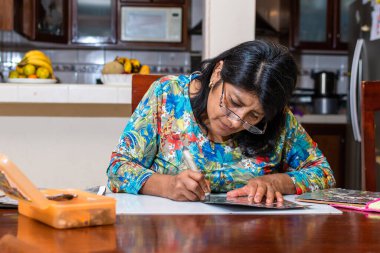 Kadın kendi elleriyle metal kabartmalı çerçeve yapıyor.