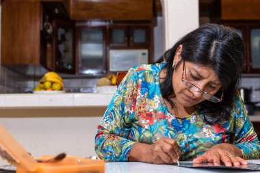 Kadın kendi elleriyle metal kabartmalı çerçeve yapıyor.