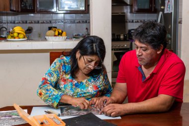 Kadın ve erkek kendi elleriyle metal kabartmalı çerçeve yapıyorlar.