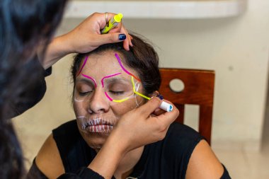 Kadın başka bir kadına makyaj yapıyor. Ölüler günü partisi için.