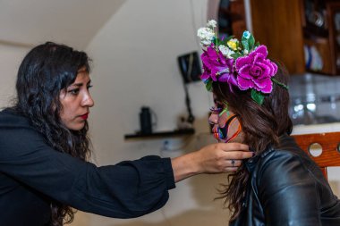 Kadın başka bir kadına makyaj yapıyor. Ölüler günü partisi için.