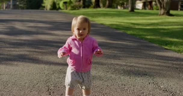 Glückliches kleines süßes Mädchen, das die Straße hinuntergeht — Stockvideo