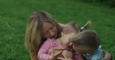 Genç bir kadın çocuklarıyla eğleniyor.