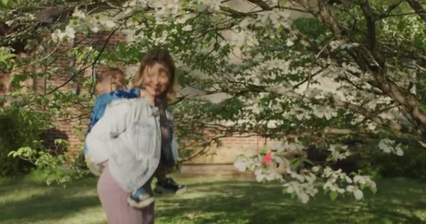 Jolie jeune femme qui s'amuse avec son petit garçon. Petit garçon sur le dos de sa mère — Video