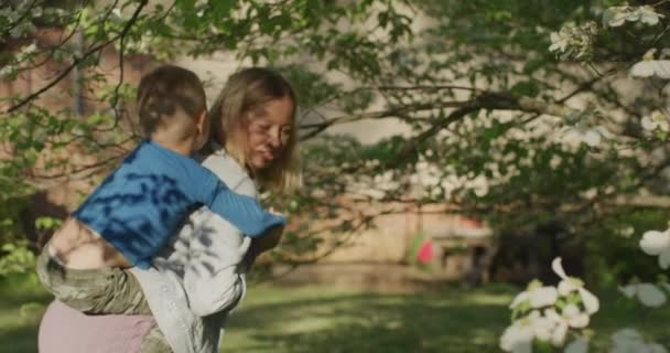 Jolie jeune femme qui s'amuse avec son petit garçon. Petit garçon sur le dos de sa mère — Video