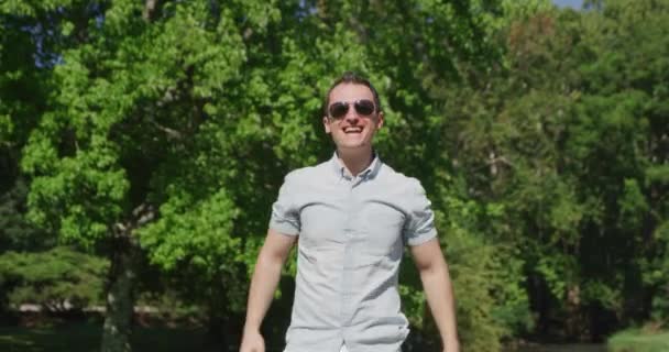 Молодий красивий чоловік співає і танцює в літньому парку 4k — стокове відео