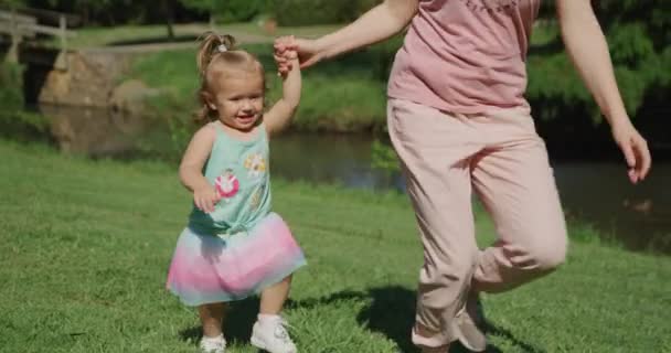 Junge schöne Frau hat Spaß beim Laufen mit ihrem kleinen Mädchen im Sommerpark. Zeitlupe 4k — Stockvideo