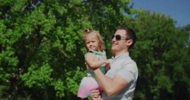 Genç ve güzel adam küçük kızıyla eğleniyor. Yavaş çekim 4k