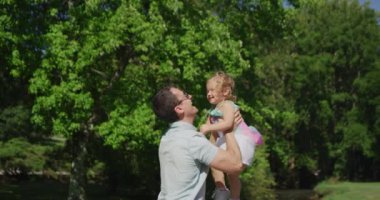 Genç ve güzel adam küçük kızıyla eğleniyor. Yavaş çekim 4k