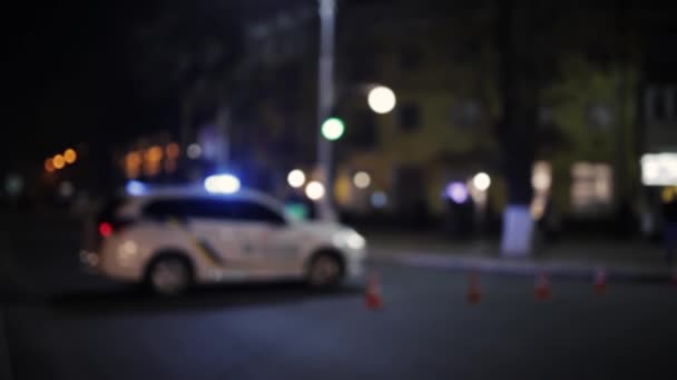 Plan non ciblé de la voiture de police avec sirènes et cônes de circulation sur la route de la ville. Urgence ou scène de crime. Veilleuses bokeh.