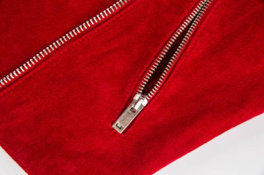 Metal fermuar ve dekoratif kapak. Beyaz arka planda kırmızı deri elbisenin düğmesi var.