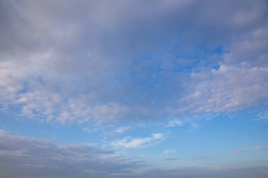 Beyaz ve pembe Cirrus bulutları mavi bir gökyüzünde yaz akşamında, arka planda