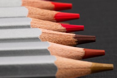 Siyah bir arka planda gümüş gömlekli, sivri renkli kalemler.