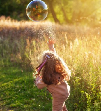 Bir yaz akşamı yürüyüş yapan bir kız, hadi sabun köpüğü atalım. 