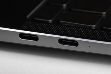 Beyaz harfli siyah ve gümüş bir dizüstü bilgisayarın parçaları ve düğmeleri.