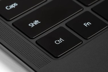 Beyaz harfli siyah ve gümüş bir dizüstü bilgisayarın parçaları ve düğmeleri.