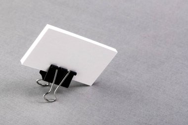 Kartvizitler için bir paket boş kağıt. Arkaplanda metal bir ataç var. İzole et