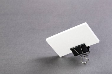 Kartvizitler için bir paket boş kağıt. Arkaplanda metal bir ataç var. İzole et